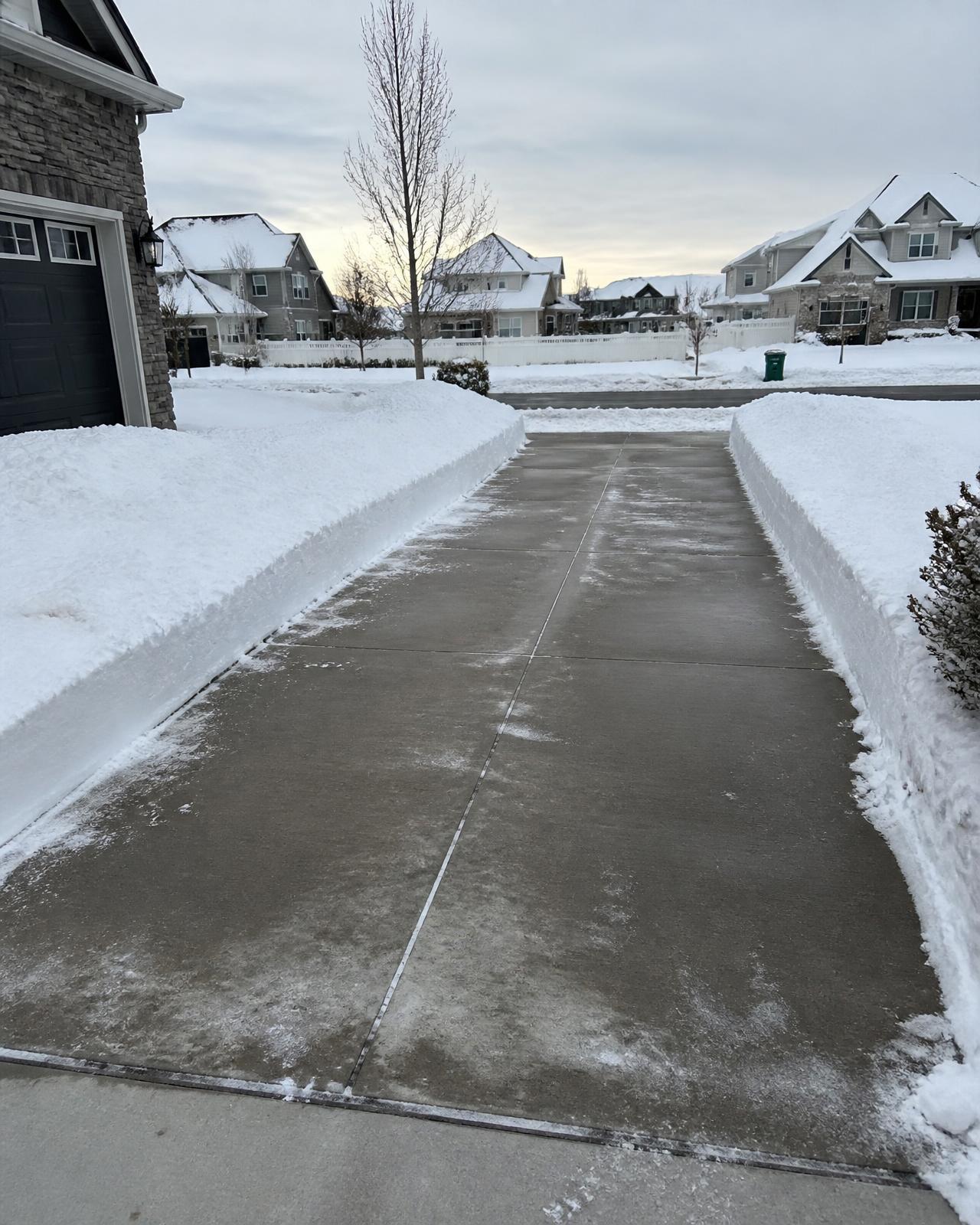 Residential driveway cleared of snow with crisp shoveled edges